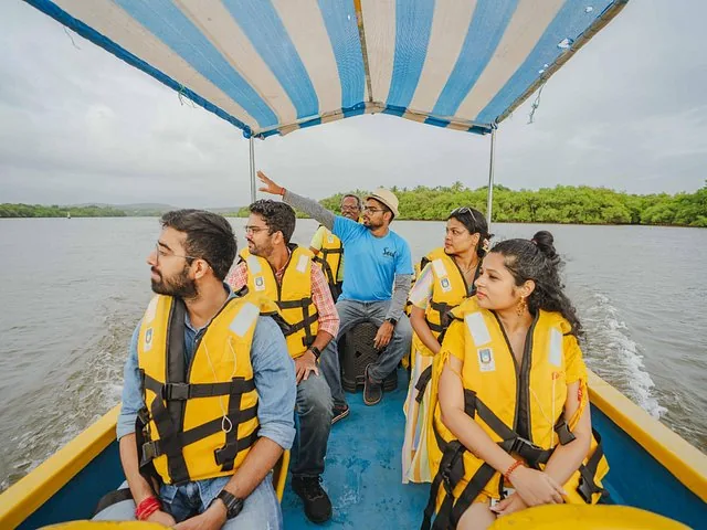 A group of people wearing life jackets riding on a small boat.