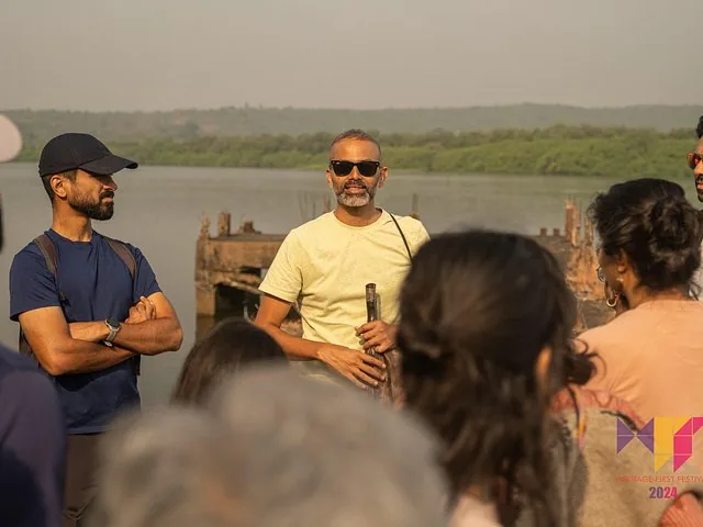 A tour guide talking to a group of people standing near a river.