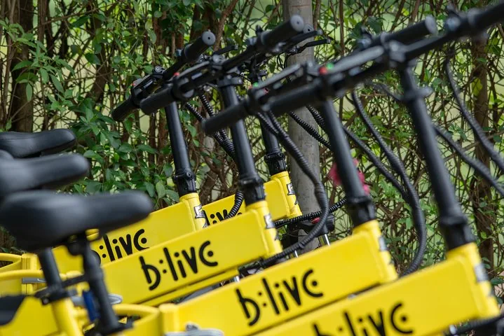 A row of yellow electric bicycles parked next to each other.